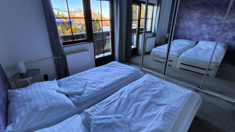 Ložnice se dvěma lůžky a dveřmi na balkon